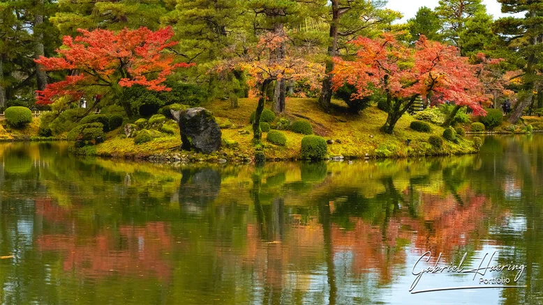 Autumn foliage in Kenrokuen Garden with maple trees in yellow, orange, and red