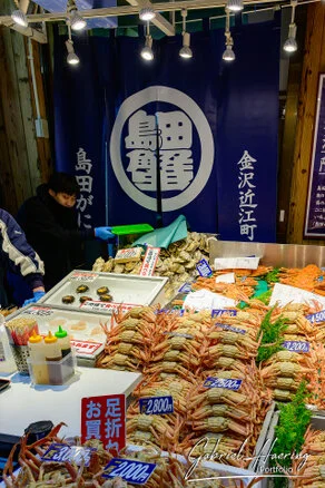 Crowded Ōmichō Market in Kanazawa during lunchtime with food stalls and visitors